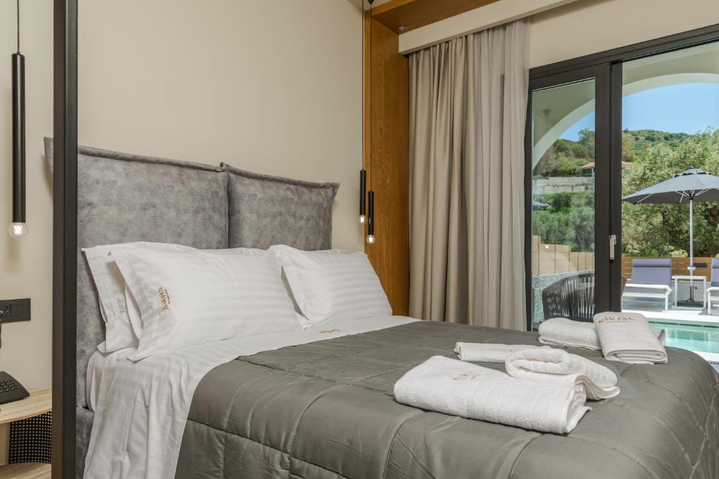 een slaapkamer met een bed met handdoeken erop bij Nikon Boutique Hotel in Kalamaki