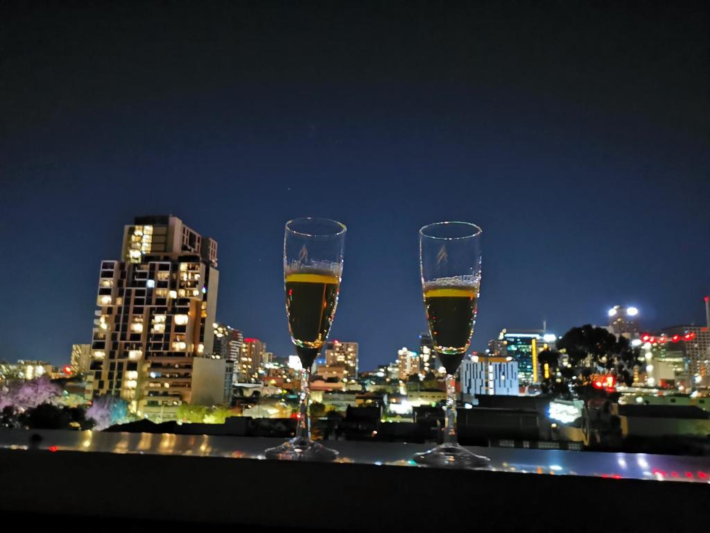 deux verres de vin sur un livre avec une vue sur la ville dans l'établissement King on Sturt, à Adélaïde