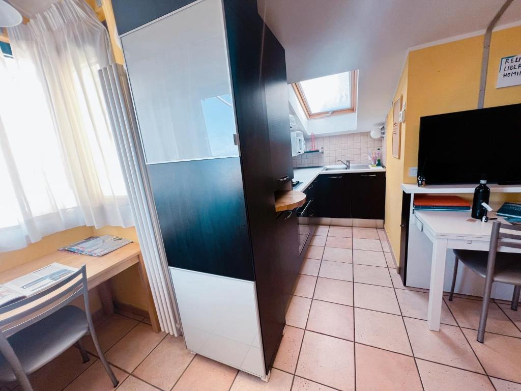 une petite cuisine avec une table et une télévision dans l'établissement Above The Sky - Flying Apartment, à Saint-Marin
