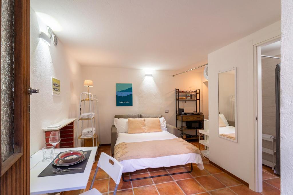 Dormitorio pequeño con cama y mesa en Lilliput Apartment by Wonderful Italy, en Bellagio