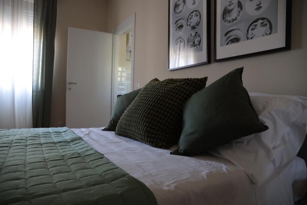 een bed met groene kussens in een slaapkamer bij B&B La Casetta in Cambiago