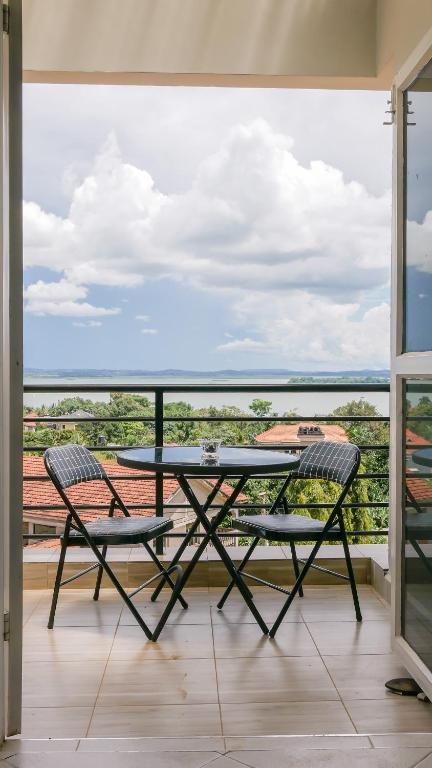 a table and two chairs on a balcony with a view at Banana Bayou - Spacious Lake View Apt in Bunga, Netflix, 24hr Security in Kampala