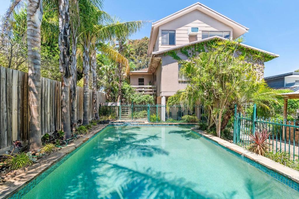 a house with a swimming pool in front of a fence at Hampton Vintage Soul with Pool in Melbourne