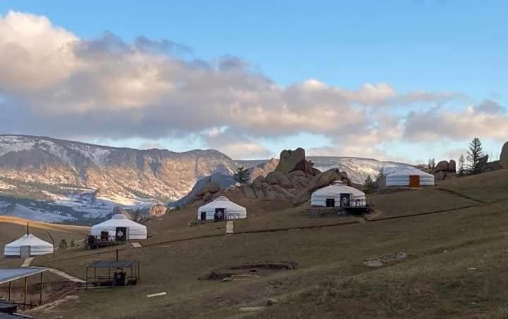 un grupo de tiendas blancas en la cima de una colina en Apache Eco Camp, Terelj Nationalpark Mongolia en Bayan Bulagiin Hural