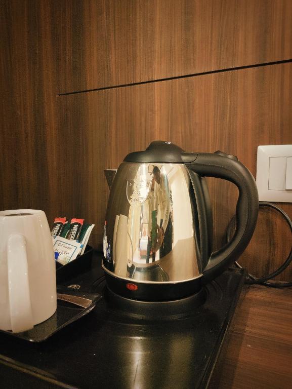 Příslušenství pro přípravu čaje a kávy v ubytování Sambhabana Hotel & Suites