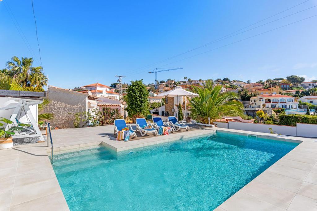 einen Pool in einer Villa mit zwei blauen Liegestühlen in der Unterkunft Villa Salada - PlusHolidays in Calpe