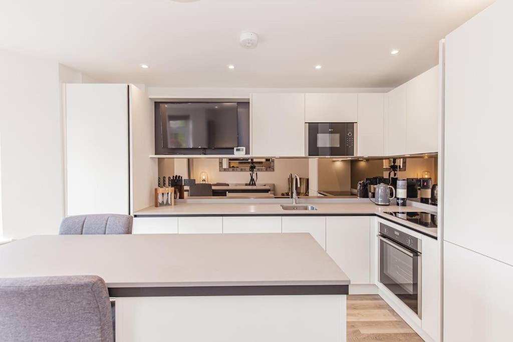 une cuisine avec des placards blancs et un comptoir blanc dans l'établissement Flat 3, 161 Crescent Road - Luxury Apartment, à Oxford