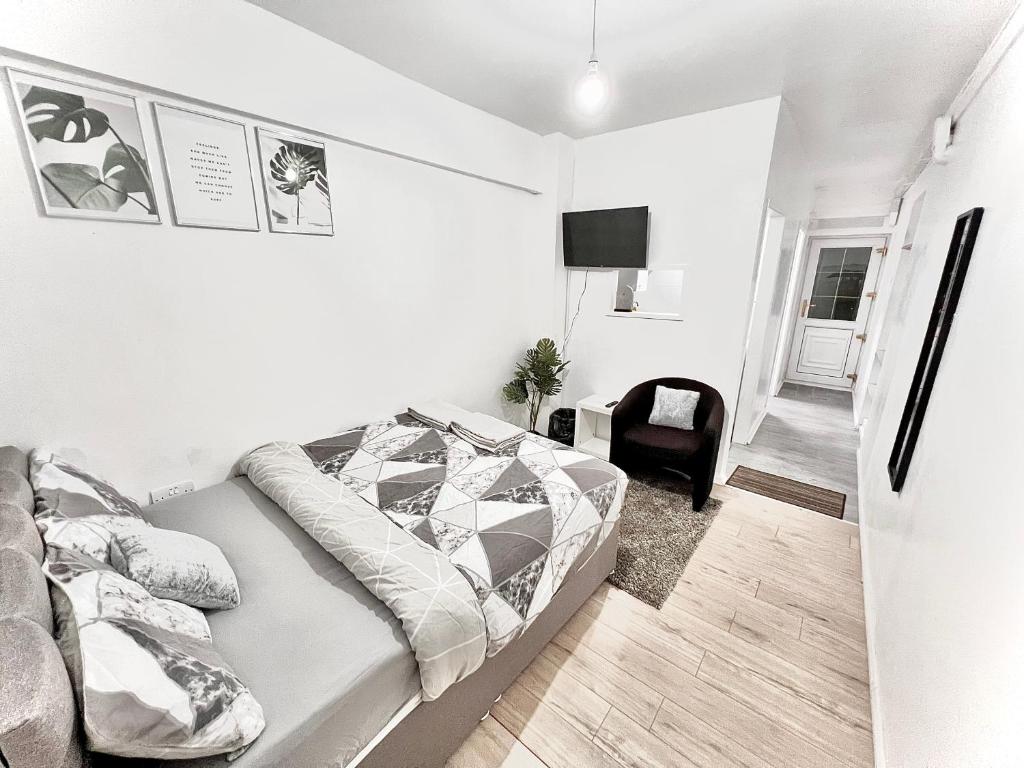 a white bedroom with a bed and a chair at Aroluchi Ville - Cosy Studio 