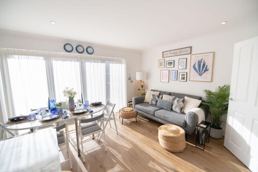 a living room with a couch and a table at La Casita - Inside the Gates of Frinton-On-Sea in Frinton-on-Sea