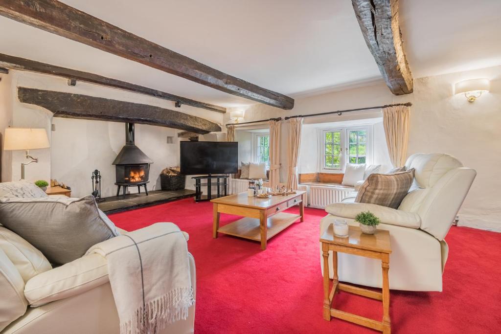 a living room with white furniture and a red carpet at farmhouse braithwaite mews in Keswick