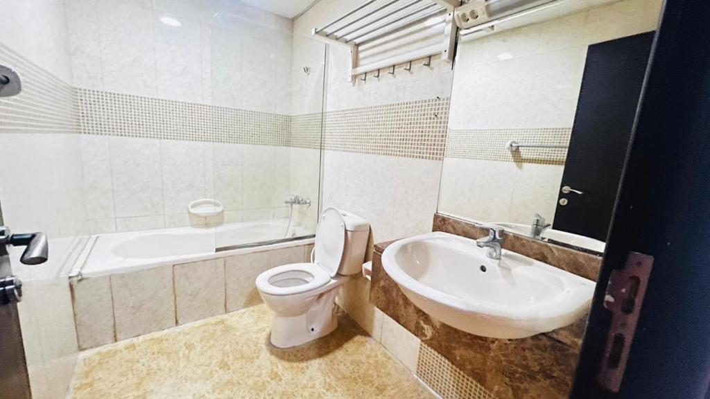 a white bathroom with a toilet and a sink at Flexible Small Partition Room Near MOE in Dubai