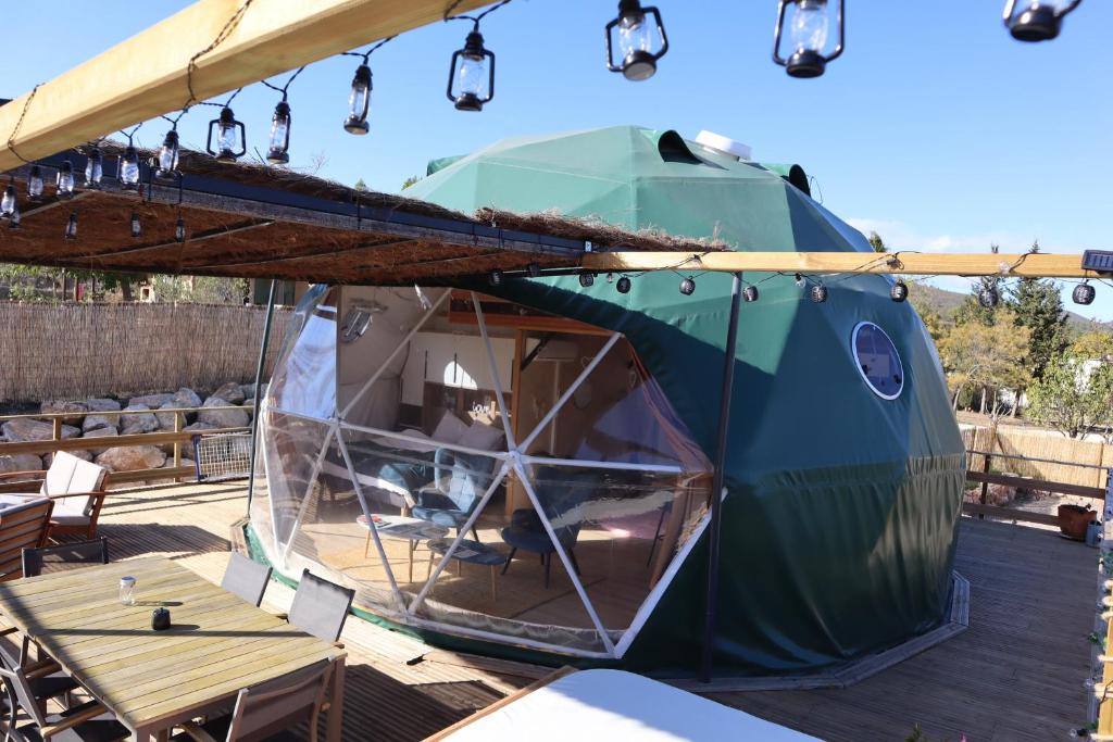 a tent on a deck with lights on it at Glamping Dôme - Dôme du Rocher rouge in Durban-Corbières