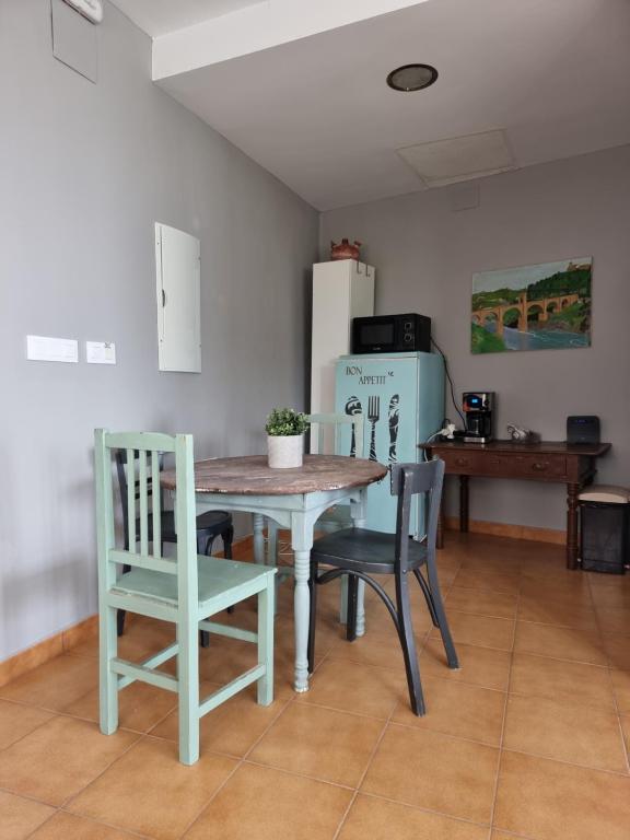 uma cozinha com uma mesa e cadeiras e um frigorífico em Albergue la Fontanina em Mata de Alcántara