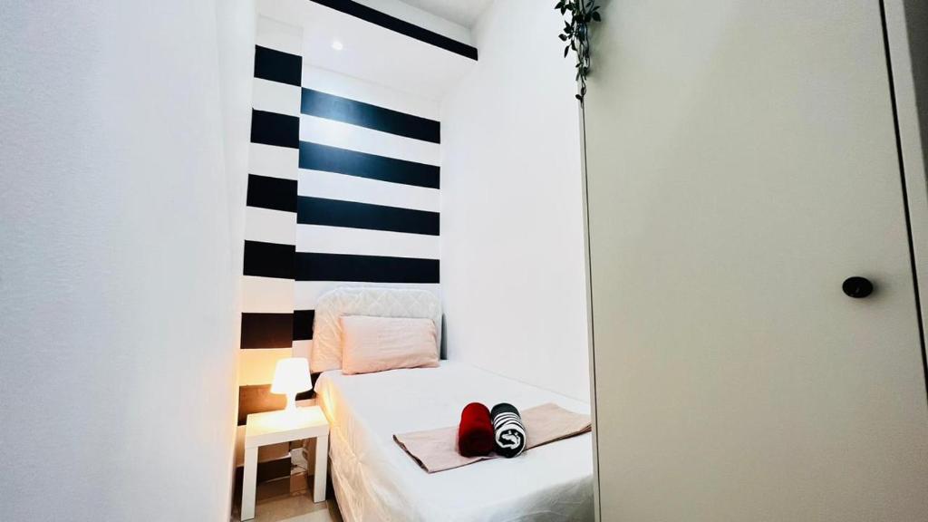 a small room with a bed and a striped wall at Brand New Private Partition Near MOE Metro in Dubai