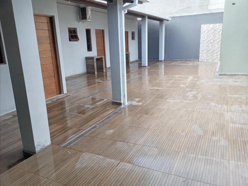 ein leeres Zimmer mit Holzboden und Säulen in der Unterkunft Cantinho do Sossego - kitnets in Cananéia