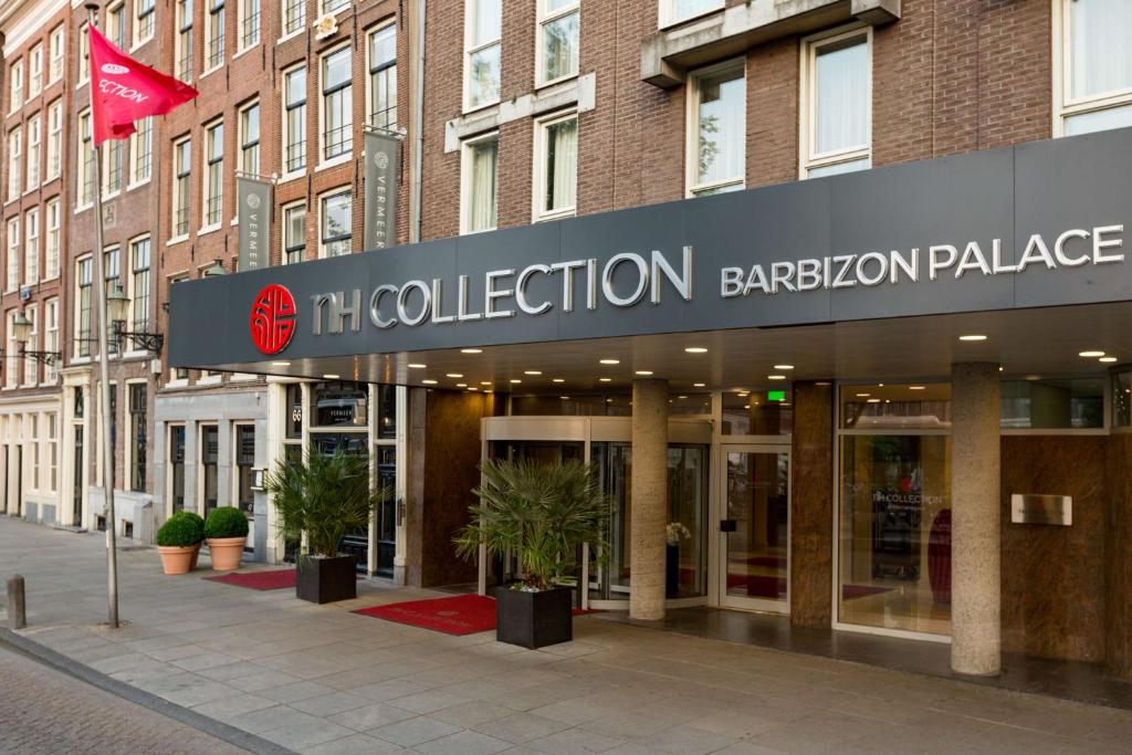 a building with a sign on the front of it at NH Collection Amsterdam Barbizon Palace in Amsterdam