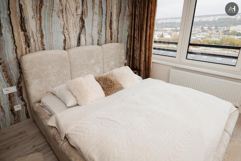 a white bed in a room with a window at AH Albelli II in Košice
