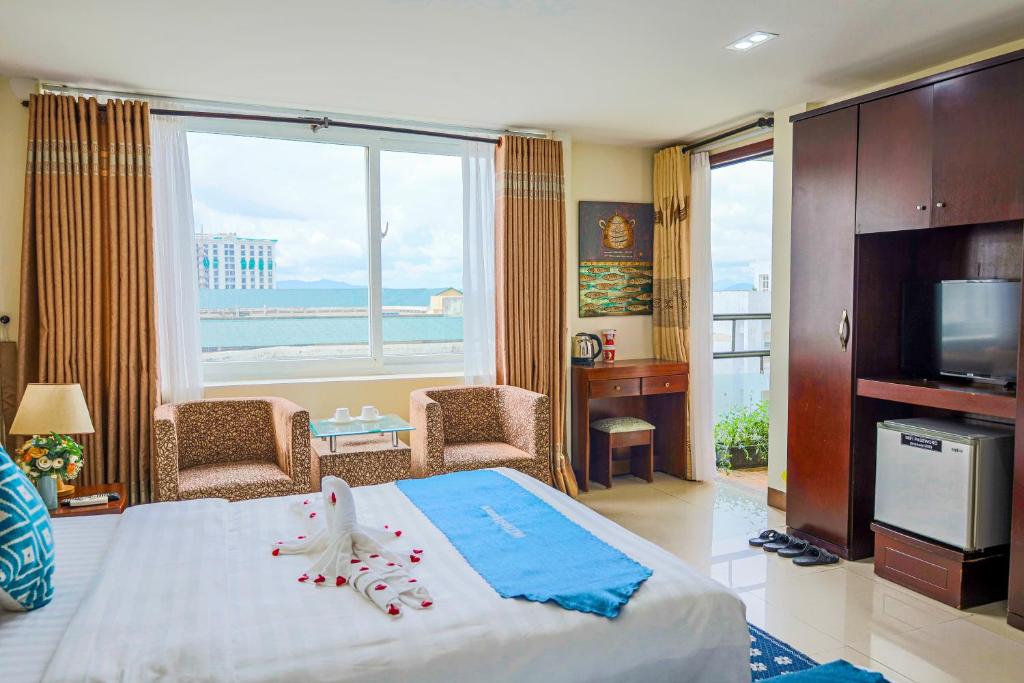 a bedroom with a bed with a view of the ocean at DMZ Hotel ,Central Hue ,Near Perfume River in Hue