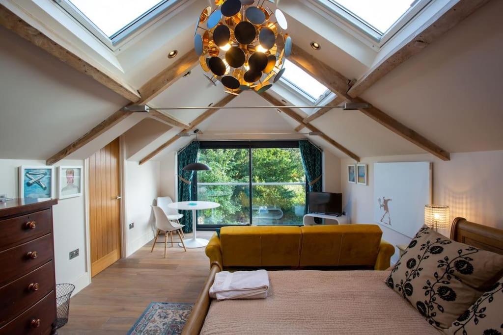 a bedroom with a yellow couch and a ceiling with skylights at The Tullet, boutique hideaway in Somerset in Banwell