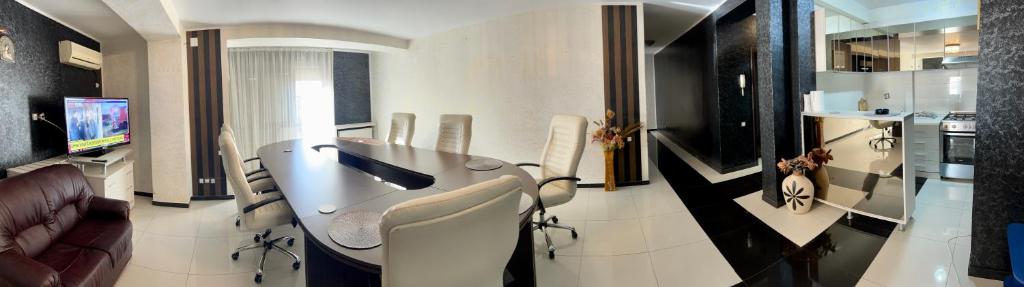 un soggiorno con tavolo, sedie e TV di Apartament zona fabricii Ford a Craiova