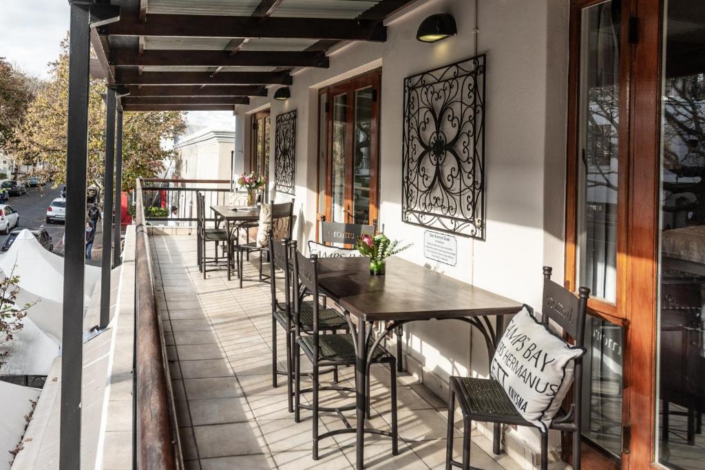 Un patio con mesas y sillas en un balcón. en Avemore Jan Cats No 5 full backup power, en Stellenbosch