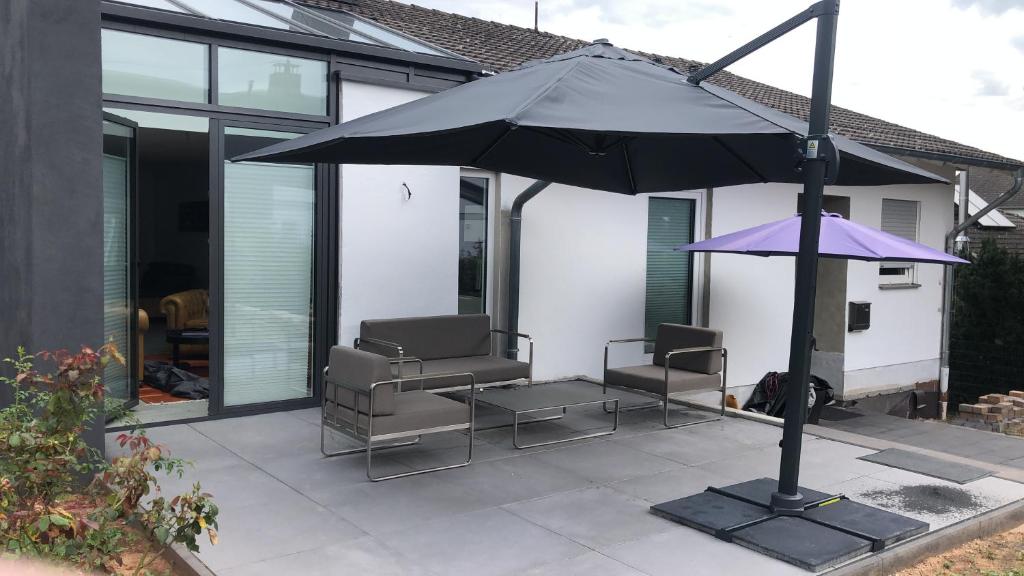 een patio met 2 stoelen en een parasol bij Wohnung in ruhiger Wohnlage in Bad Kreuznach