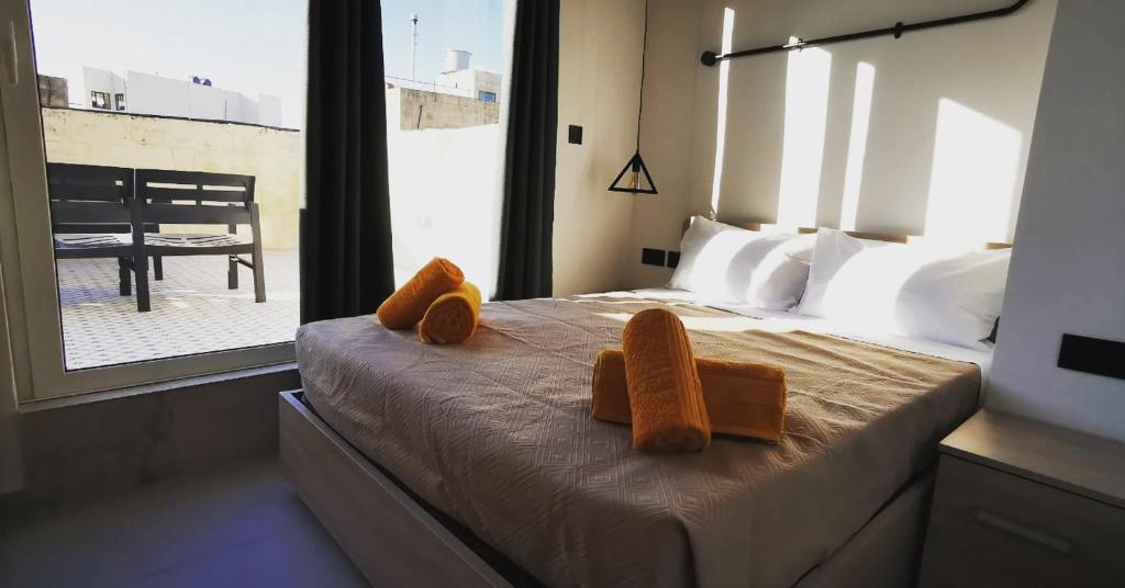 a bedroom with a bed with towels on it at Chic Penthouse industrial-style in Mosta