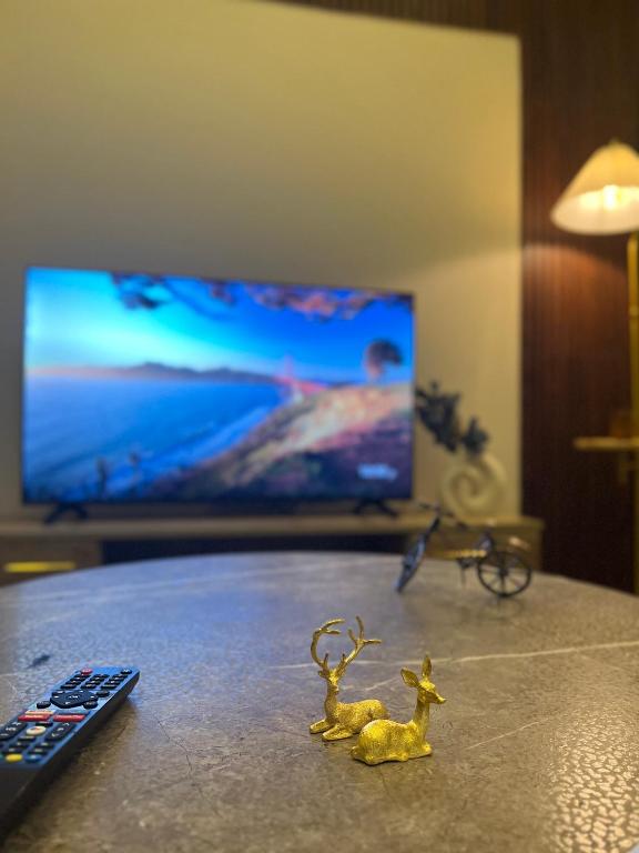 a toy deer sitting on a table next to a remote control at Your first comfortable residence in Riyadh