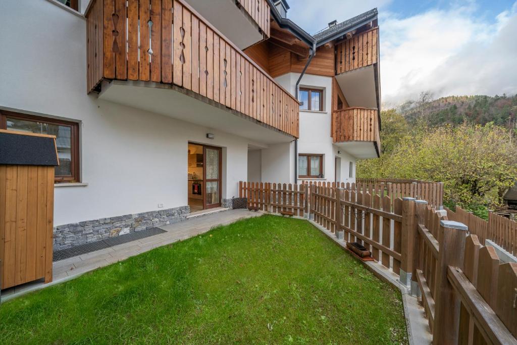 un patio con una valla y una casa en Alpi Giulie Chey, en Camporosso in Valcanale