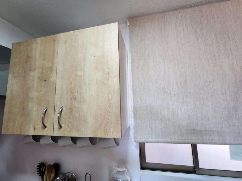 Playa y Descanso Chic في كوكيمبو: خزانة خشبية في مطبخ مع نافذة