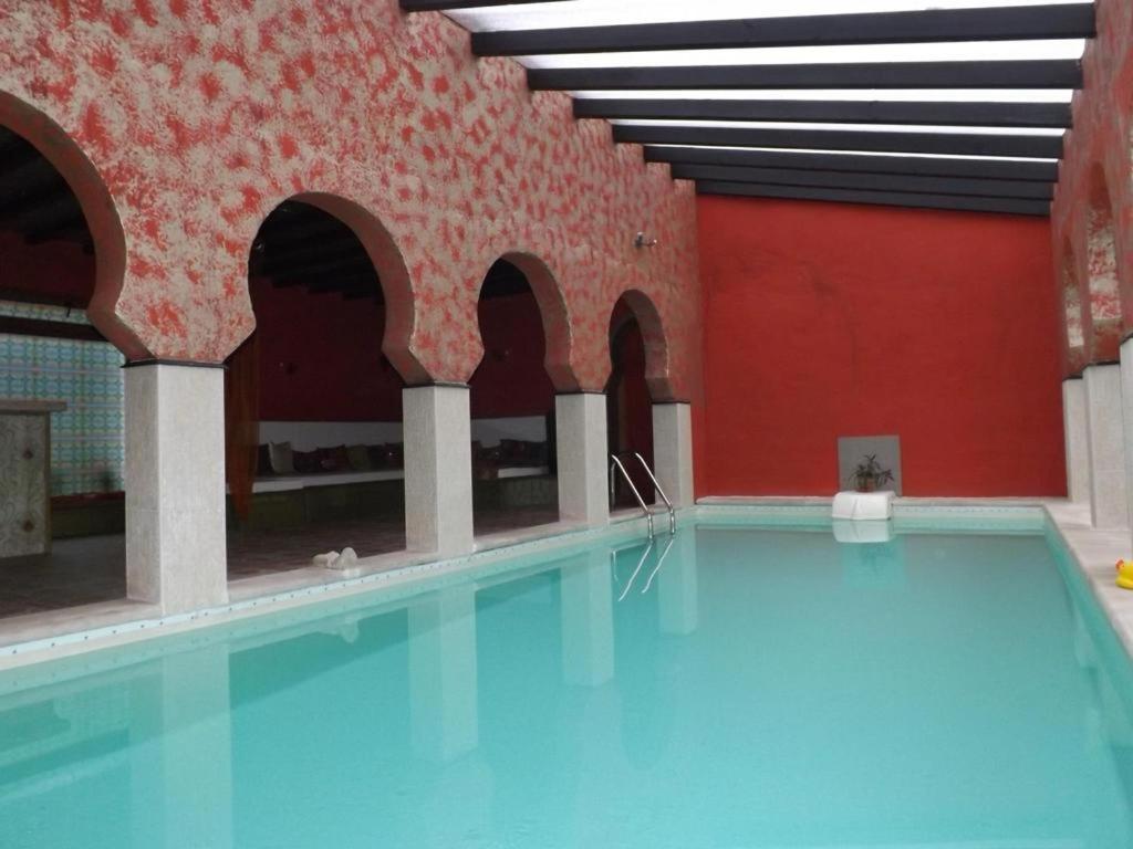 an indoor swimming pool with blue water in a building at Antaviana Cantabria in Cabezón de la Sal