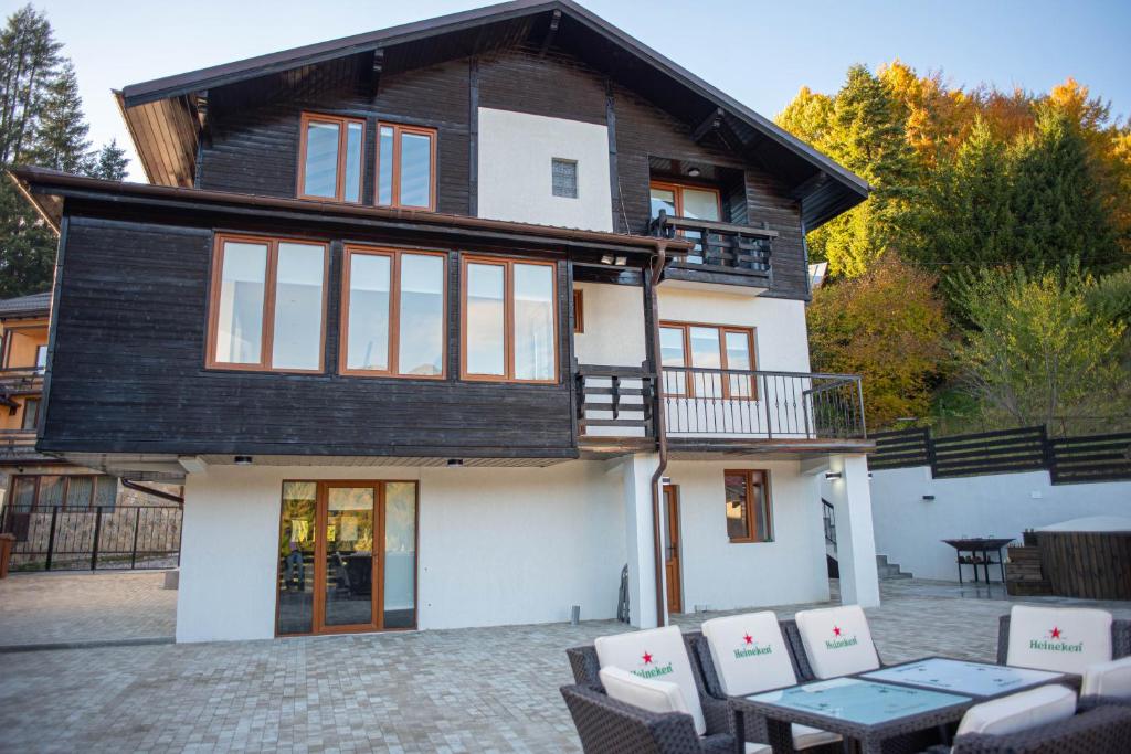 a house with a table and chairs in front of it at VILLA KYRA LUXURY in Sinaia