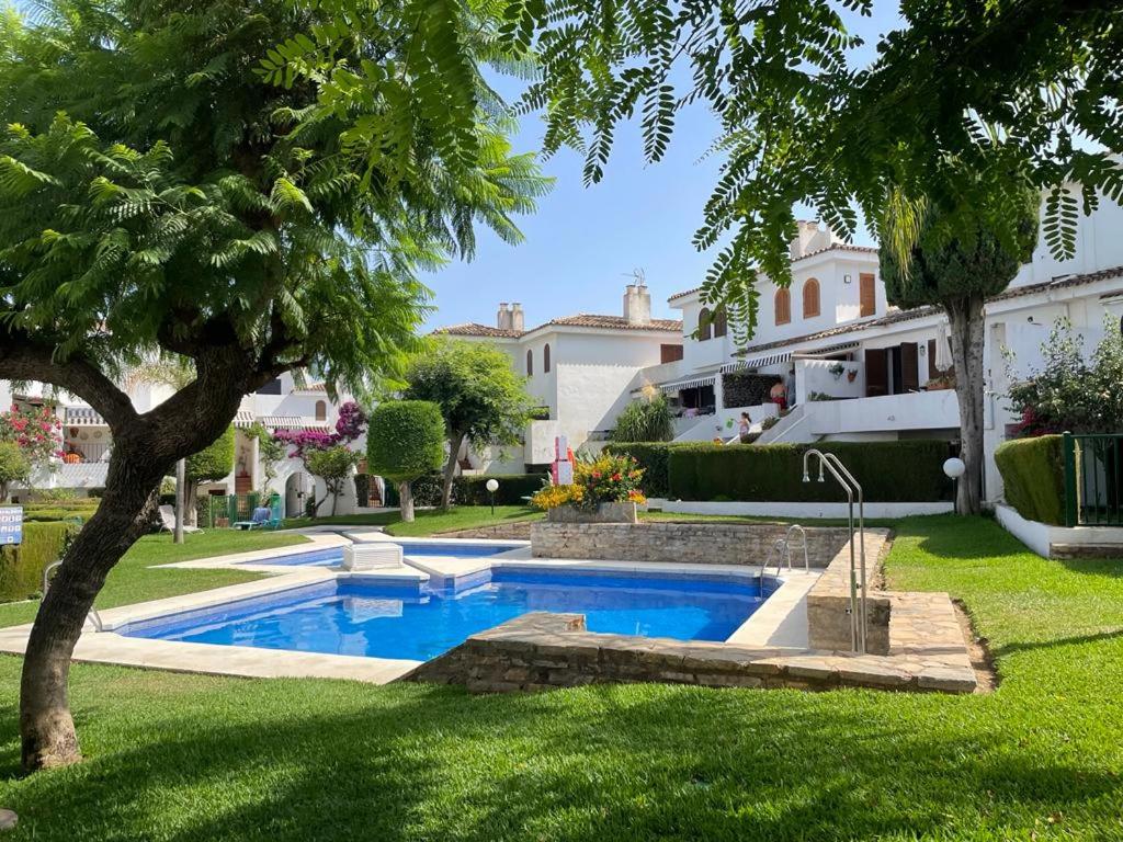 een zwembad in de tuin van een huis bij 4 Bedroom Townhouse 200 meters from the Beach! in Estepona