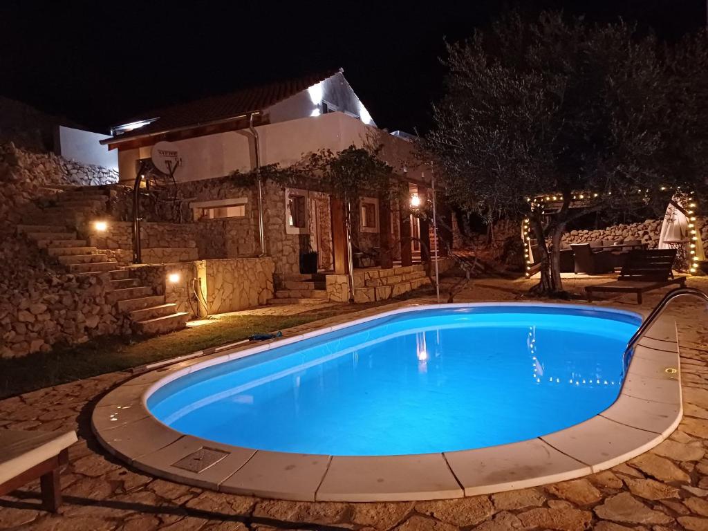 una piscina di fronte a una casa di notte di Holiday House Pulina a Punat
