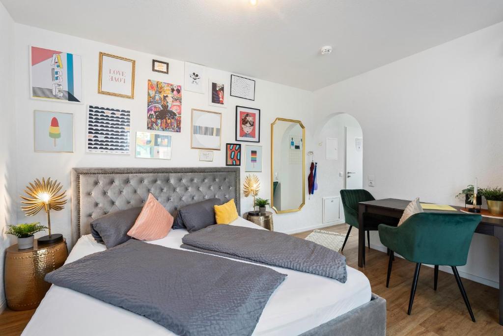 een slaapkamer met een bed, een tafel en een bureau bij ANYTIME - Apartments in Langenargen in Langenargen