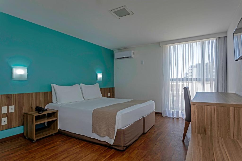 馬塞約的住宿－Marinas Maceió Hotel，一间卧室设有一张大床和蓝色的墙壁