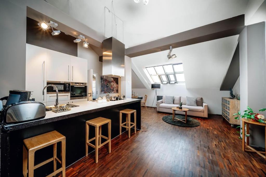 a large kitchen and living room with a counter and chairs at Amazing Apartment in Prague