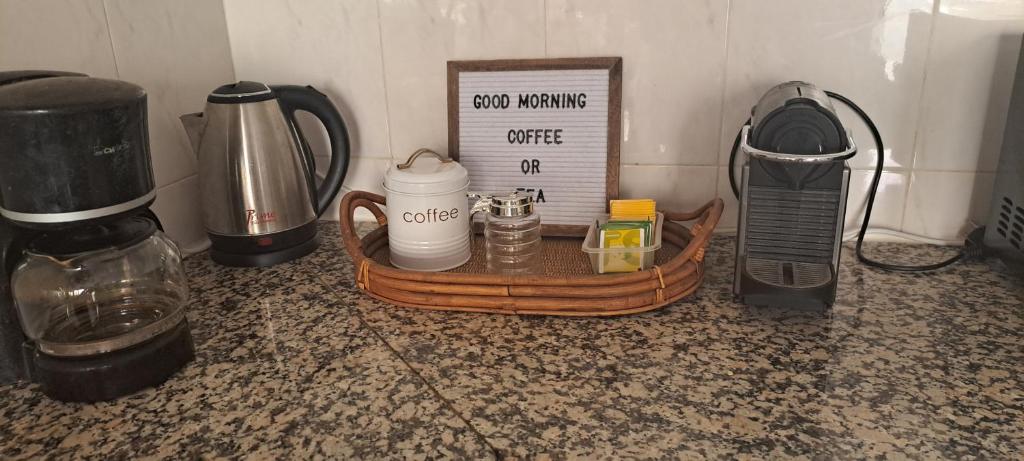 a counter top with a tray with a coffee pot and a clock at Mendes Homestay - B&B In The Heart Of Praia Ext in Praia
