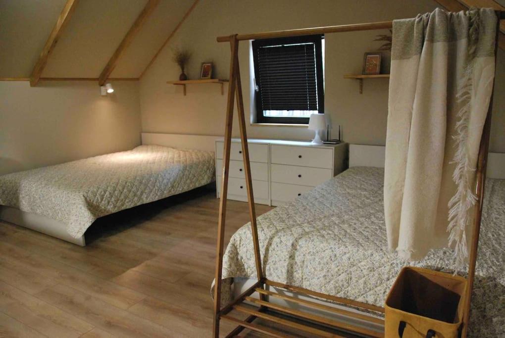 a bedroom with two beds and a window at Domek SzumiSosna2 in Życiny