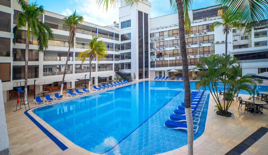 uma grande piscina com palmeiras num edifício em Sol Caribe San Andrés All Inclusive em San Andrés