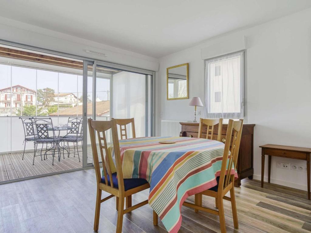a dining room with a table and chairs and a balcony at Appartement Saint-Jean-de-Luz, 2 pièces, 4 personnes - FR-1-4-586 in Saint-Jean-de-Luz