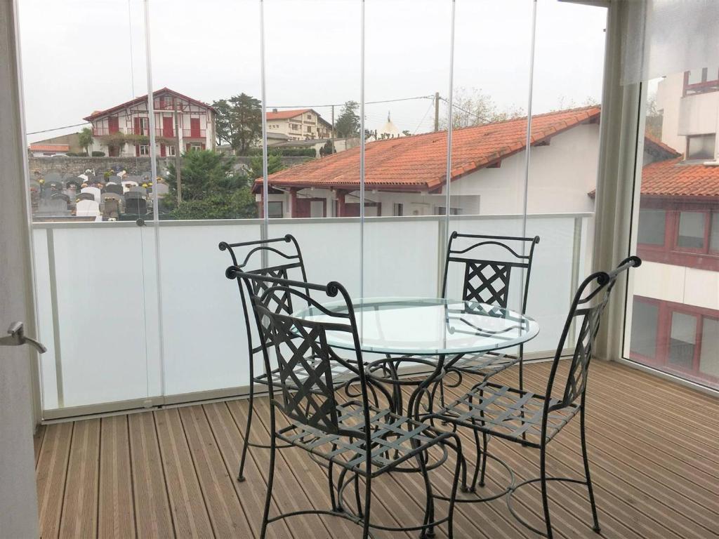 a glass table and two chairs on a balcony at Appartement Saint-Jean-de-Luz, 2 pièces, 4 personnes - FR-1-4-586 in Saint-Jean-de-Luz