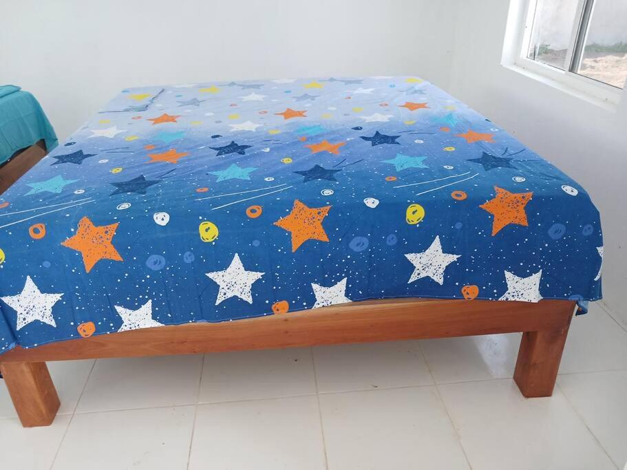 にあるStay Jamaica Villaのベッド(星空の青い掛け布団付)