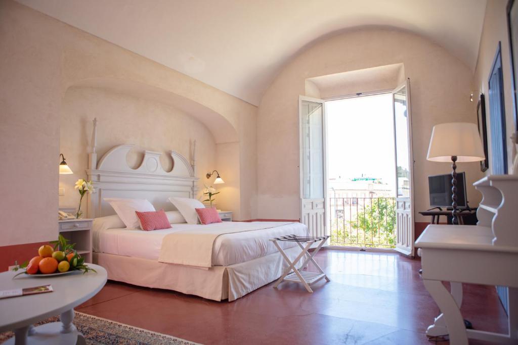 a bedroom with a large bed and a large window at Monasterio de San Francisco in Palma del Río