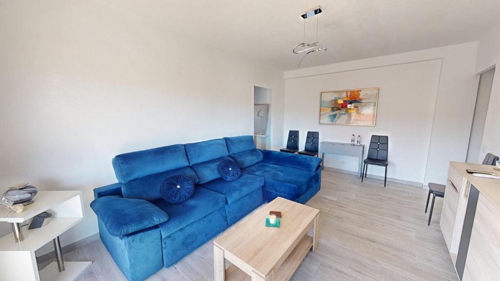 uma sala de estar com um sofá azul e uma mesa em Casa Claveles - A Murcia Holiday Rentals Property em Santiago de la Ribera