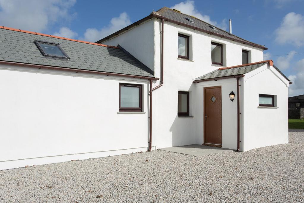 a white house with a garage and a driveway at Cornish Views in Camborne