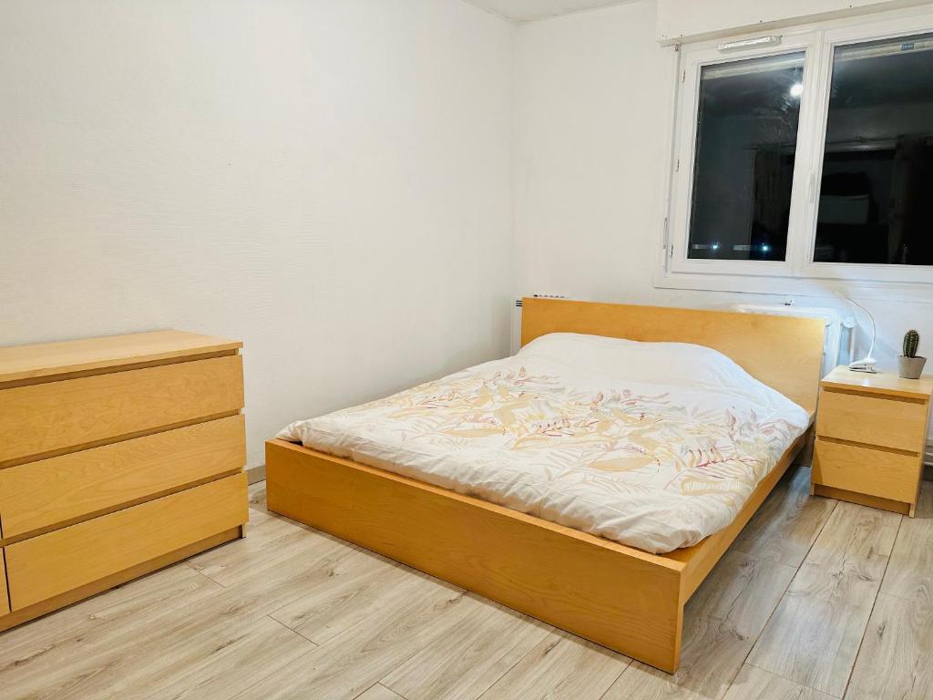 um quarto com uma cama, 2 cómodas e uma janela em Tom House em Lille