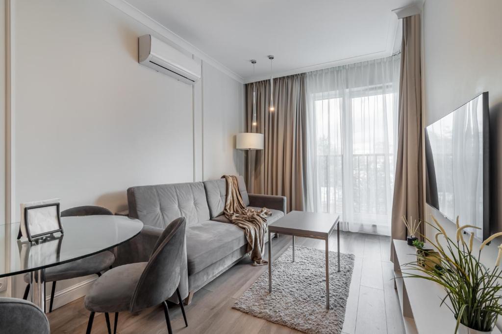 a living room with a couch and a table at Golden Apartments Warsaw - Luxury And Bright Apartment - Siedmiogrodzka 3 in Warsaw