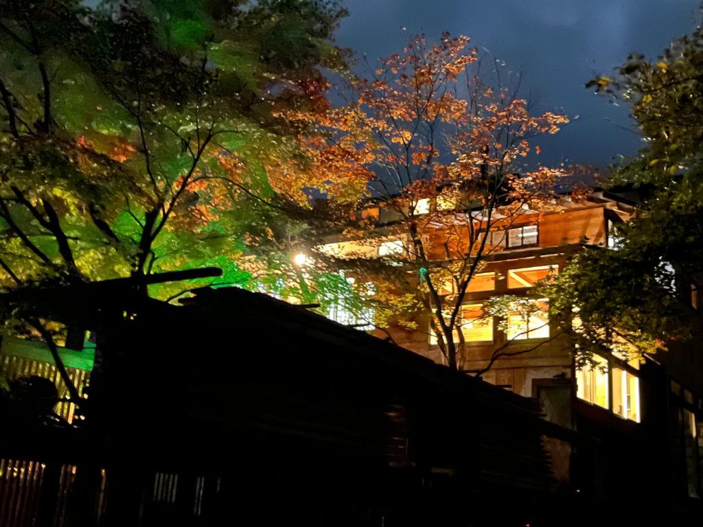 a view of a building at night with trees at 那須リゾートMOMIJI room stay in Nasu