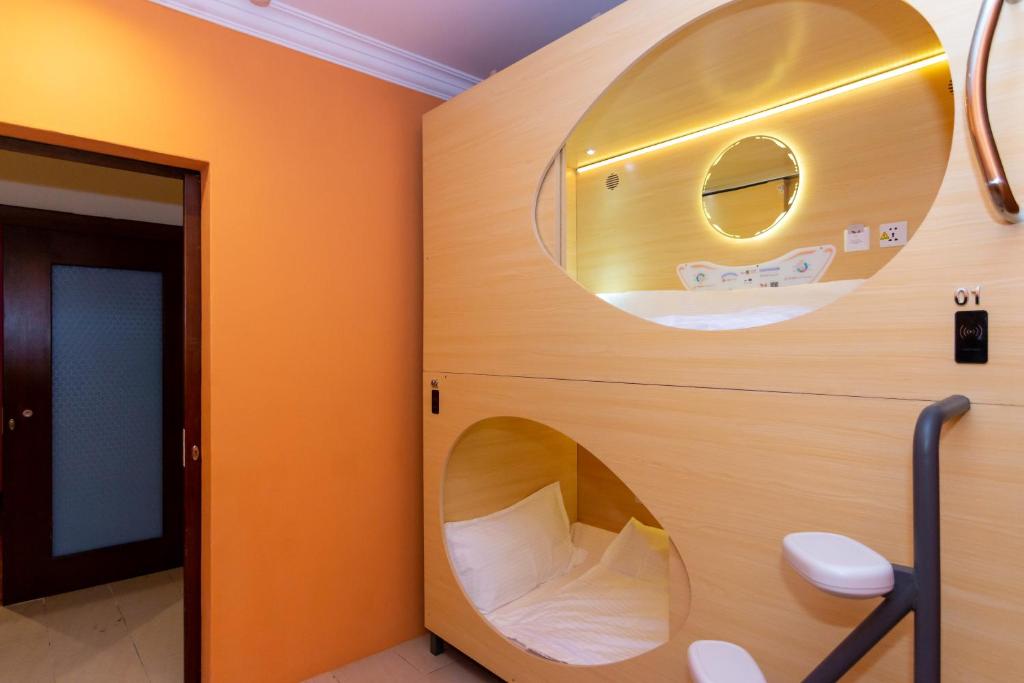 uma casa de banho com WC e espelho redondo em Momostay em George Town